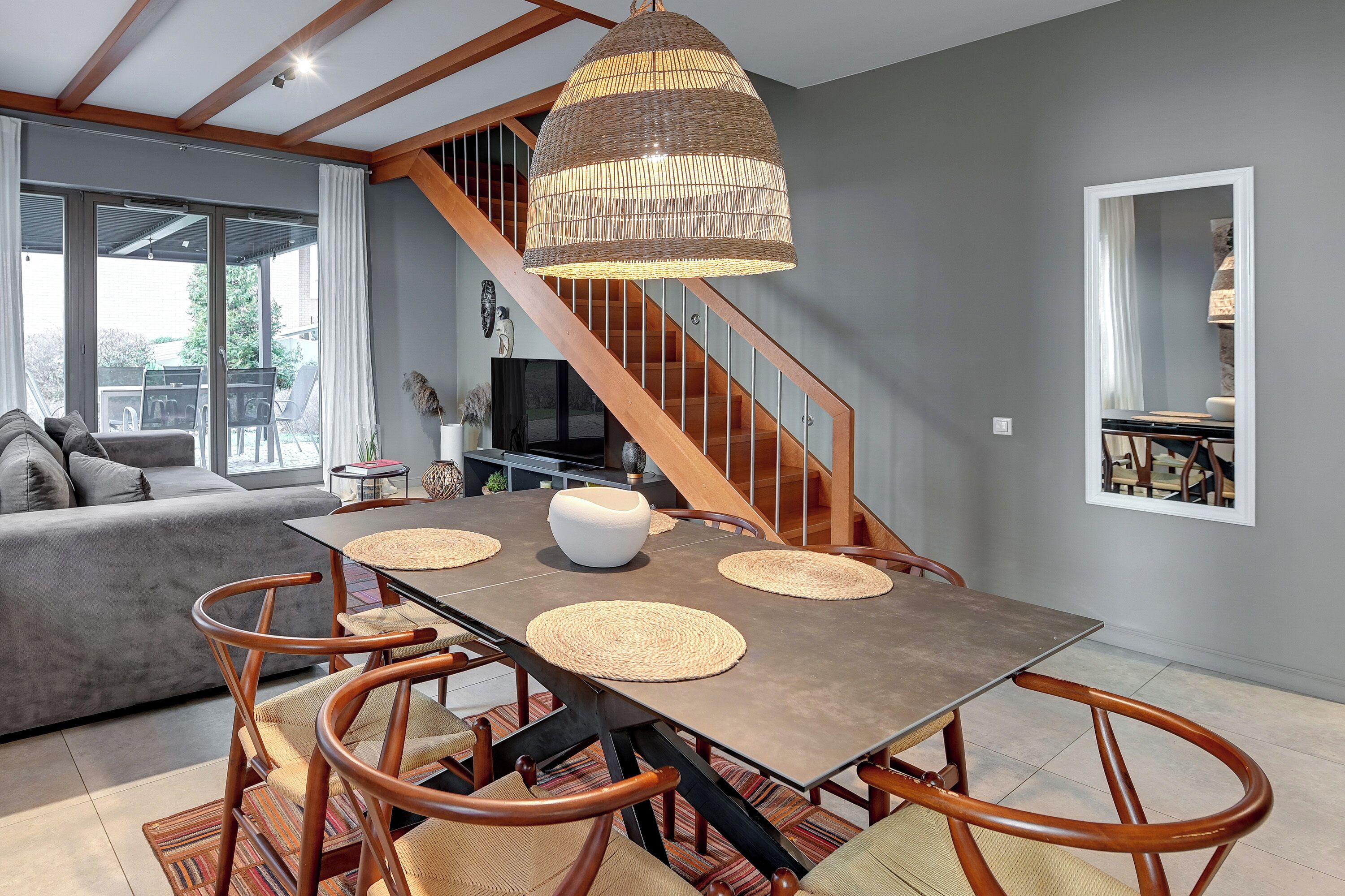 Un espace repas comprenant une table, des chaises et un luminaire suspendu.
