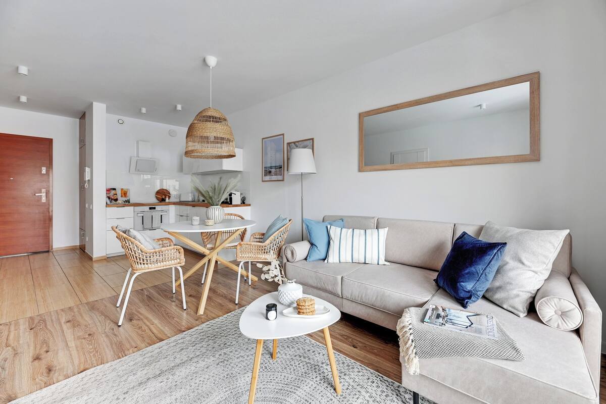 A modern living room with a sofa, coffee table, and dining area.