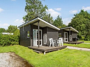 A two-story cabin with a deck and outdoor seating. - 6 Person Holiday Park Home in Malling (Malling)