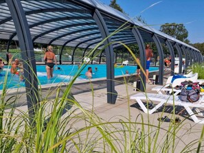 A covered swimming pool area with people swimming and lounging. - 6 Person Holiday Park Home in Malling (Malling)