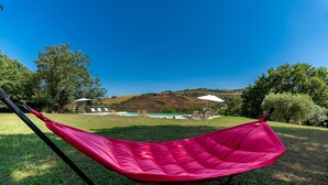 A red hammock in a grassy area with a pool and hills in the background. - Luxury Private Villa Three Oaks W/ Star View - Beautiful Spot (Volterra)
