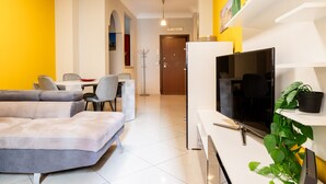 A modern living room with a sofa, TV, and potted plant. - Romantic Malatesta in Rome (Rome)