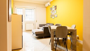 A compact living space with a dining area, a sofa, and a refrigerator. - Romantic Malatesta in Rome (Rome)