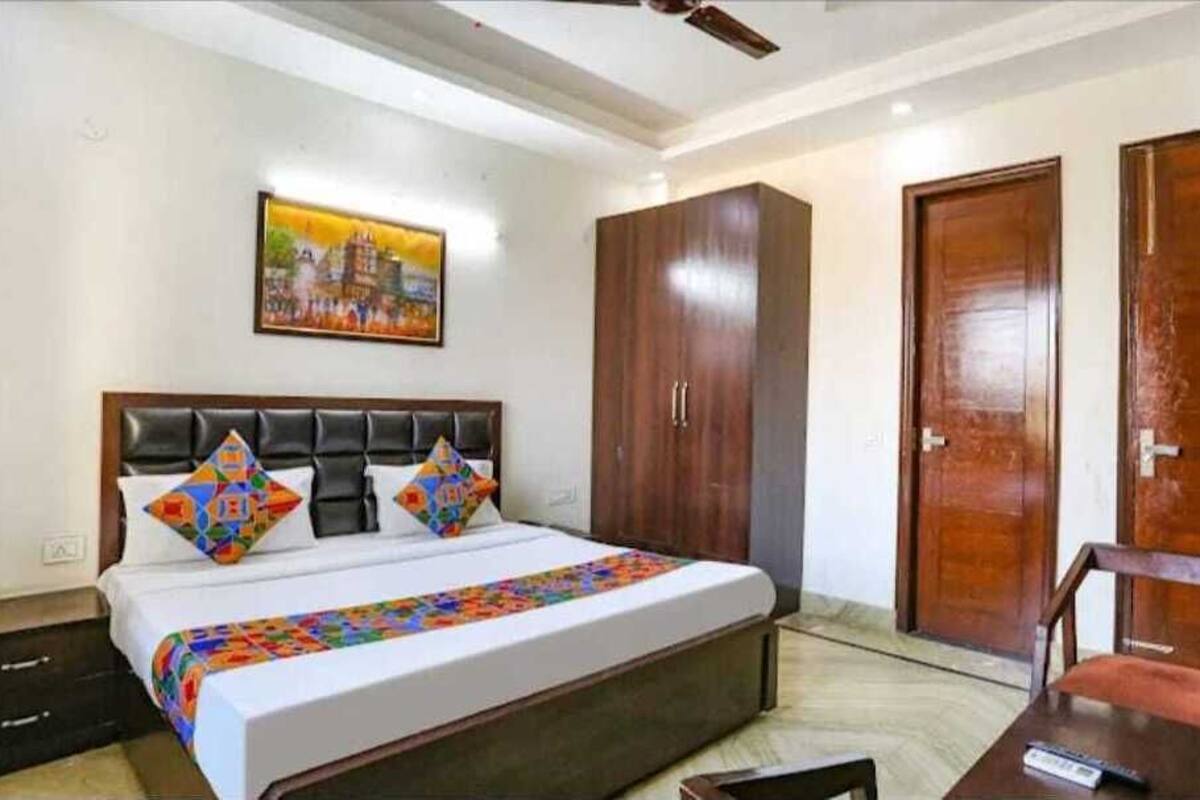 A bedroom with a bed, a wardrobe, and a desk.