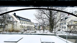 A snow-covered urban scene with buildings and a river. - Beautiful Old Building Apartment In The Center (St. Gallen)