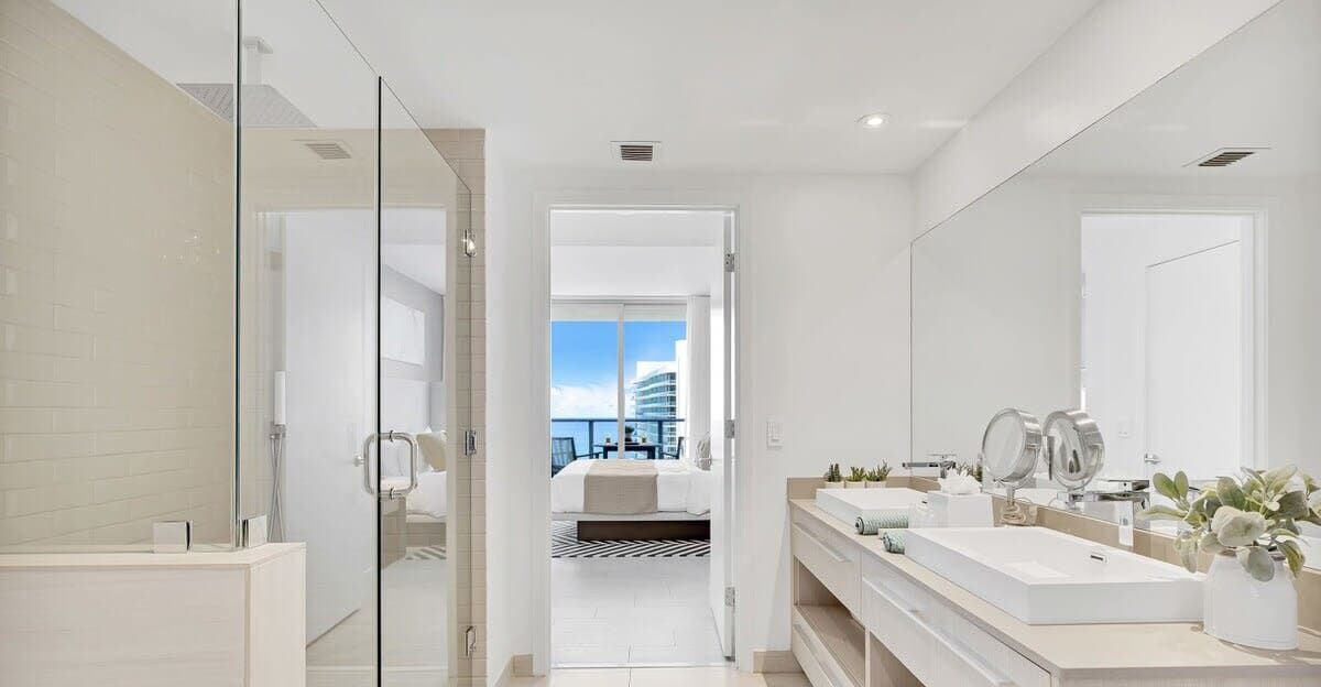A modern bathroom with a glass shower enclosure, a double sink vanity, and a large mirror.