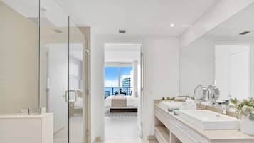 A modern bathroom with a glass shower enclosure, a double sink vanity, and a large mirror.