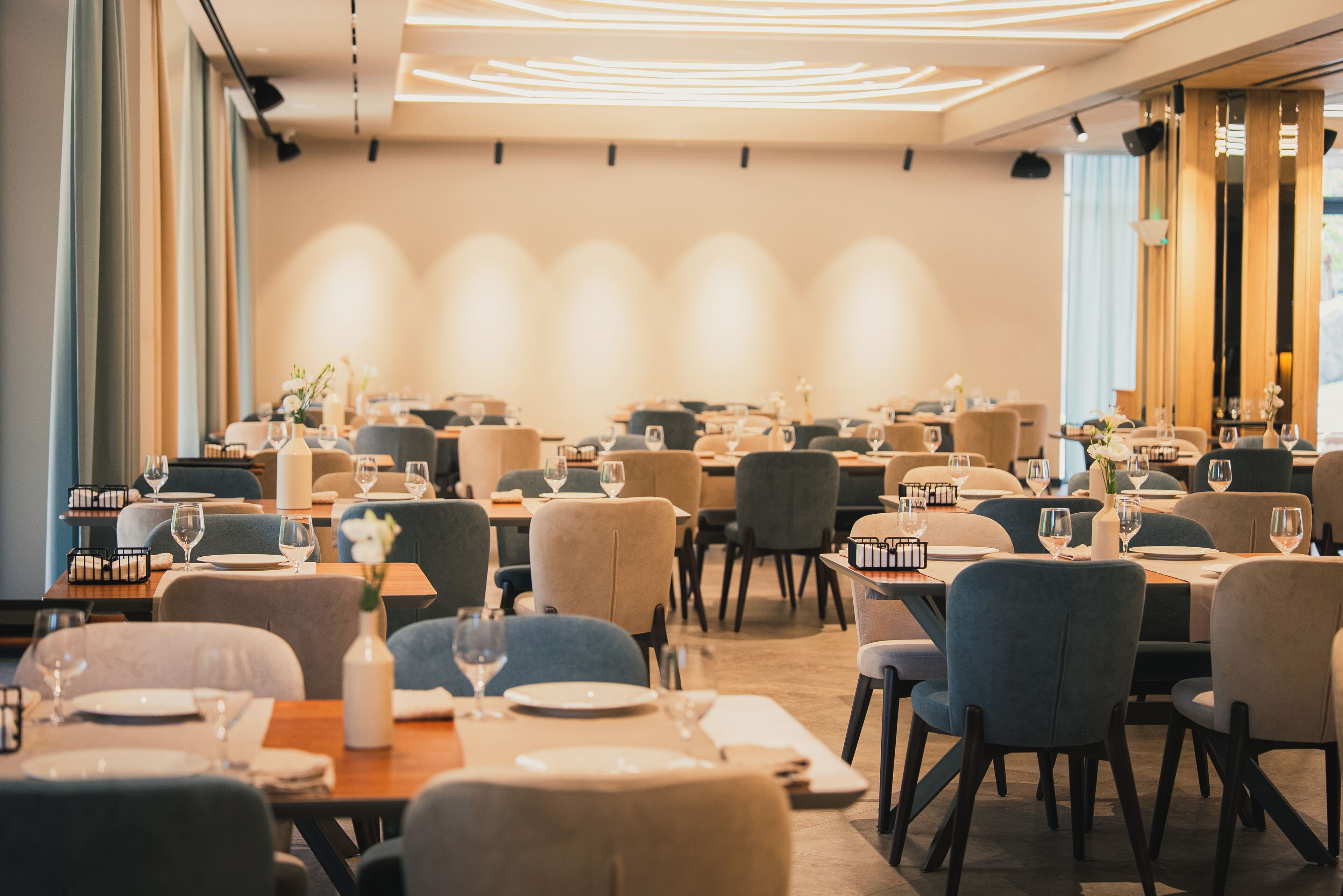 Un restaurante amplio con varias mesas y sillas, dispuesto en una distribución moderna.
