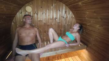 A wooden sauna with a bench and a circular ceiling.