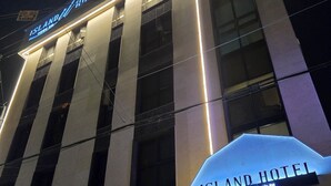 A modern hotel building with illuminated signage. - Hotel Island (Ansan)
