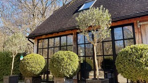 A traditional building with a tiled roof, large windows, and a gravel driveway. - Idyllic Cottage in the heart of The South Downs (Haslemere)