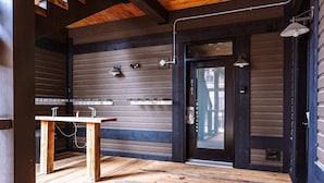 A wooden interior with a sink and a door with a glass panel.