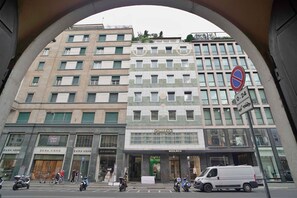 A multi-story building with retail stores on the ground floor, including Zara Home and Woolrich. - Chic & Quiet Apartment in San Babila (Milan)
