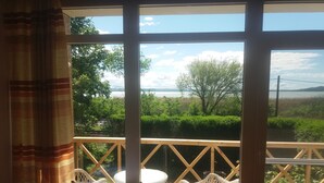 Ein Zimmer mit großem Fenster und Blick auf eine natürliche Landschaft, einem kleinen Tisch und einem Stuhl.