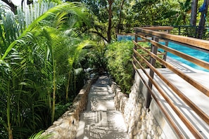A pathway leading to a pool surrounded by lush greenery and stone walls. - Sea View Paradise Retreat by Sea N' Rent (Cóbano)