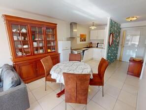 Cozy living space with a dining area, wooden cabinet, and fully equipped kitchen.