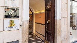 Entrada de un edificio con una puerta de madera oscura, un letrero que dice 'ROSSANOVA HAIR & BEAUTY' y un letrero que dice 'Heritage Innovation Planet'.