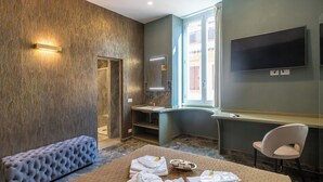 Un baño moderno con un banco, un lavamanos, un espejo y un televisor montado en la pared.