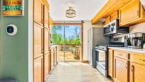 A modern kitchen with wooden cabinets, a stainless steel refrigerator, and a built-in oven.