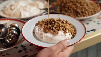 A person pouring syrup onto a dessert.