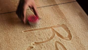A hand smoothing a textured surface with a tool.
