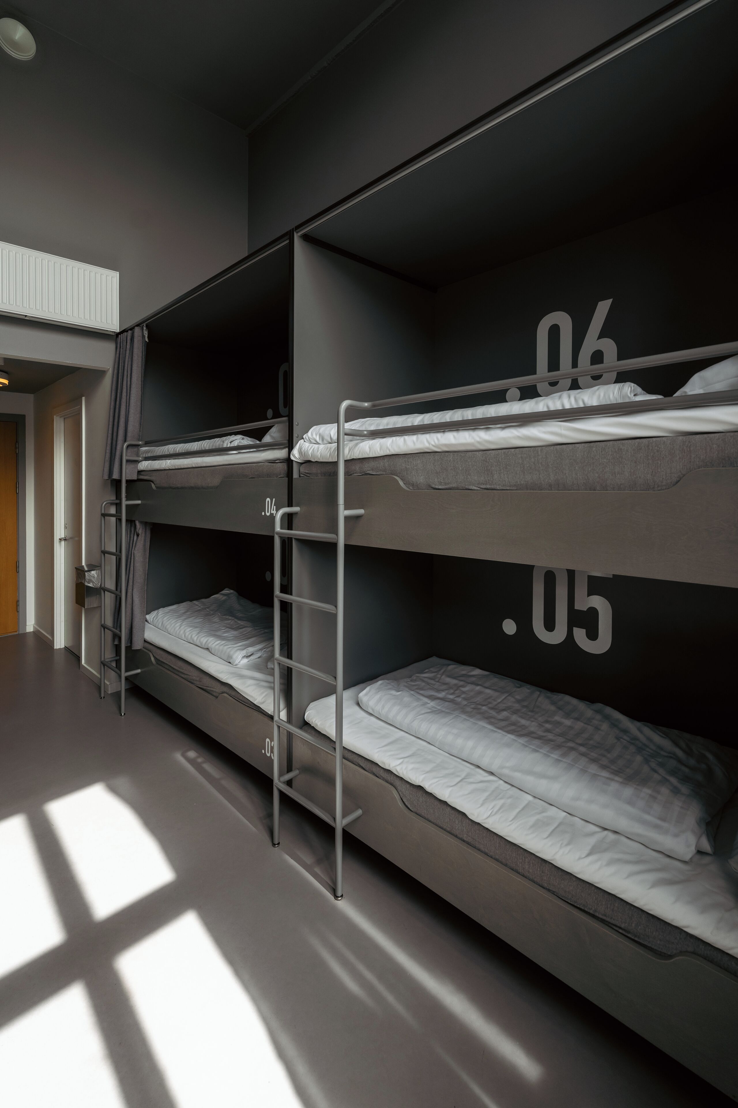 Una habitación con literas, una escalera y una puerta.