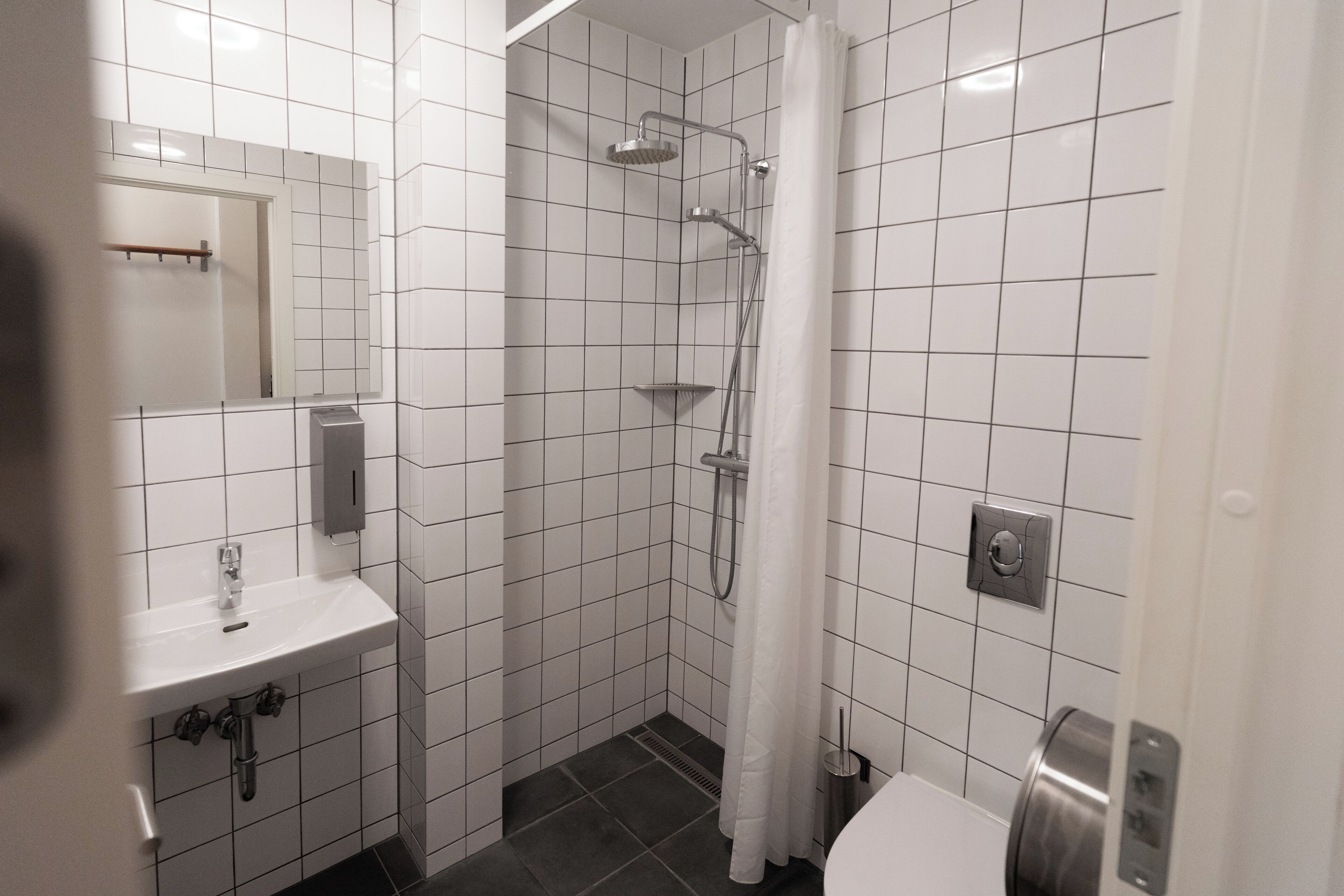 A modern bathroom with a shower, toilet, and sink.