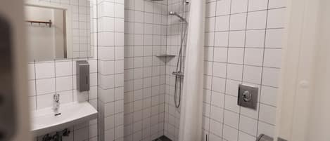 A modern bathroom with a shower, toilet, and sink.