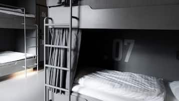 Une chambre avec un lit superposé, une échelle, un rideau et un numéro sur le mur.