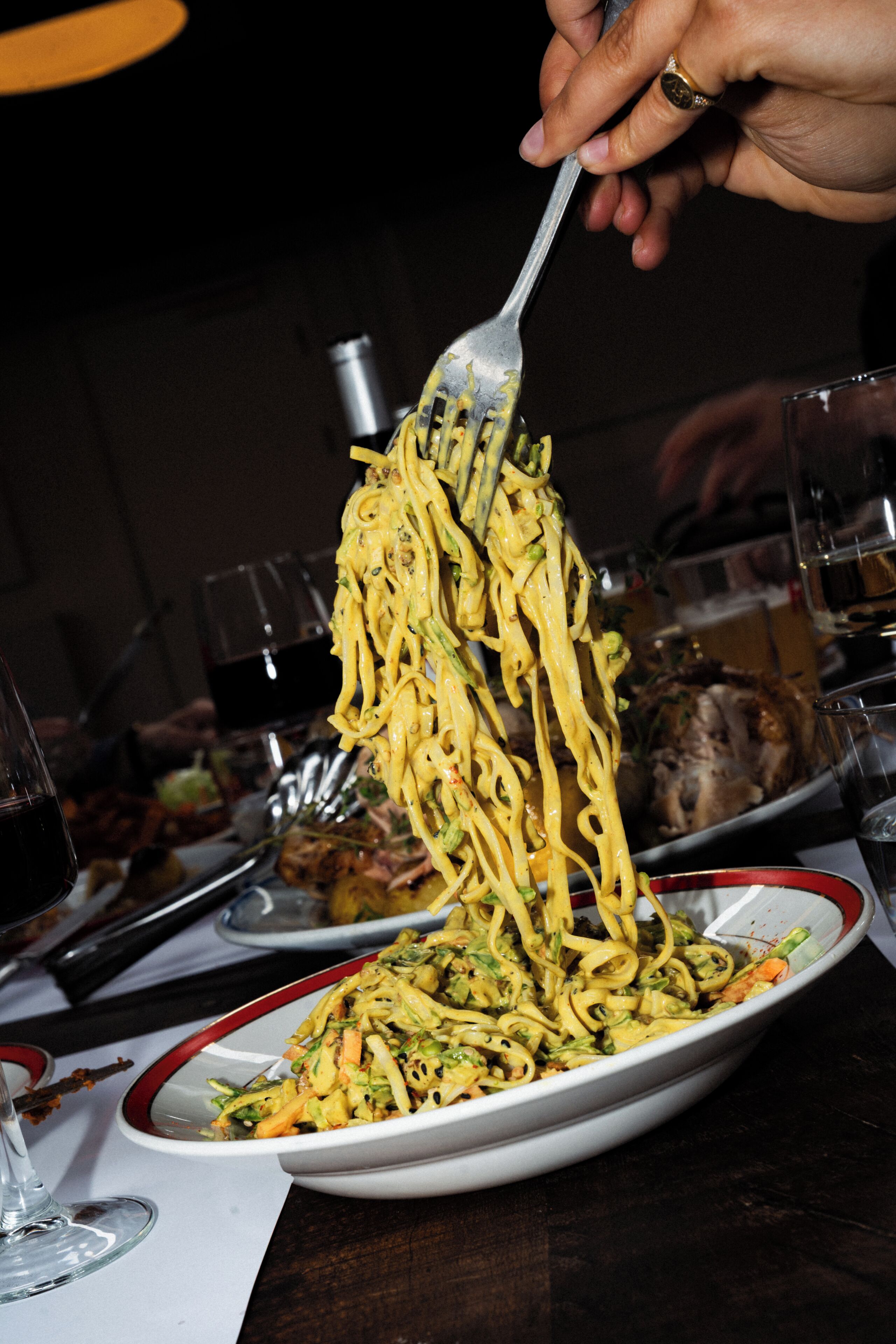 Une personne qui sert des spaghettis dans une assiette.