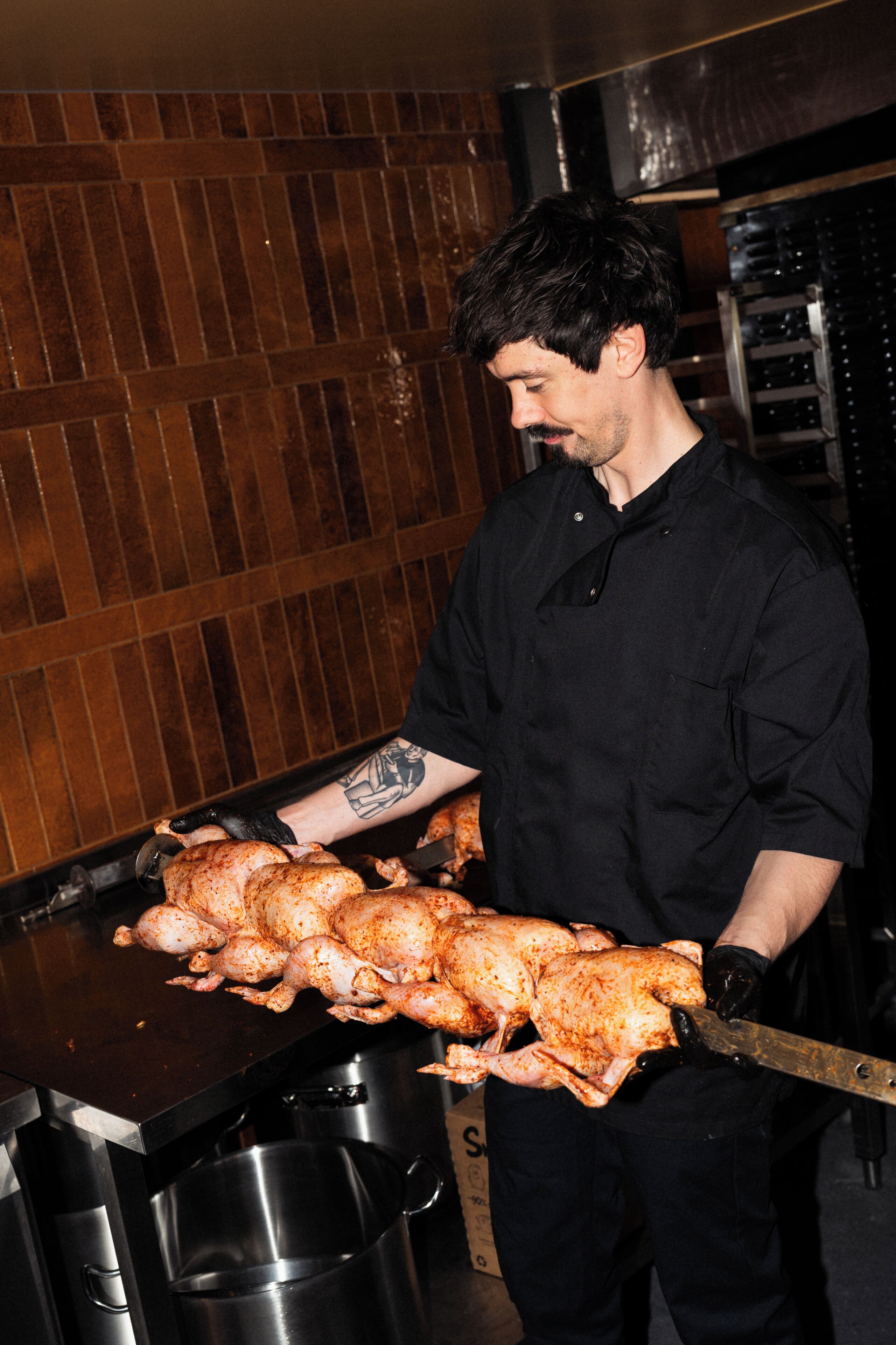 A person holding a large roasted chicken.