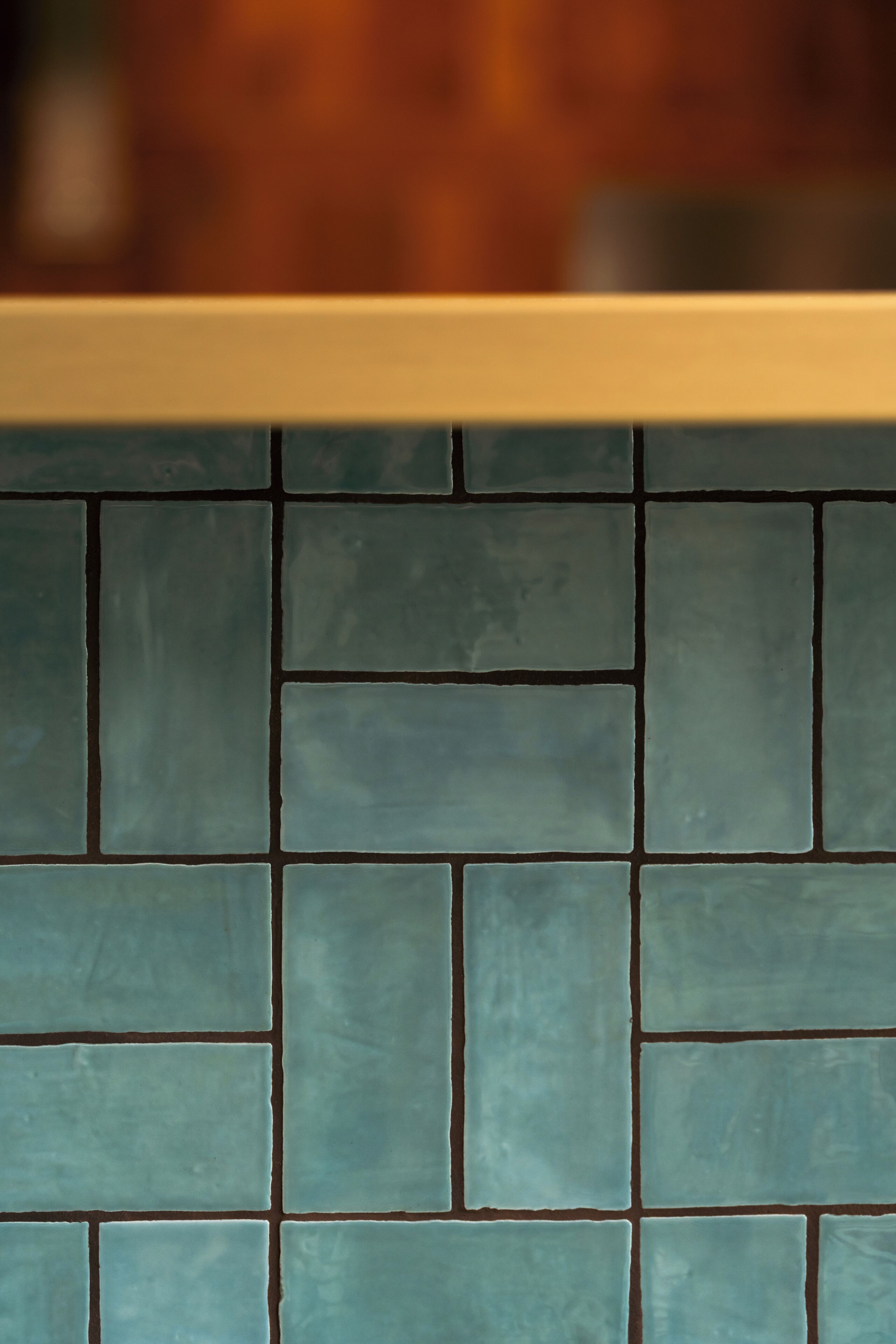 Un gros plan d’un mur recouvert de carreaux, avec un motif répétitif de carreaux carrés.