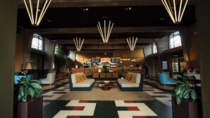 A lobby with a bar area, seating, and plants. - Robertas Society (Aarhus)