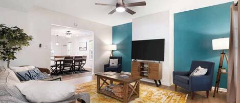 Relax in this inviting space with a flat-screen TV, comfortable armchair, and a potted plant.