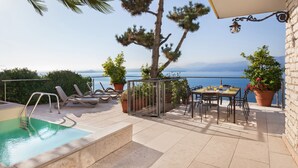 A rooftop terrace with a pool, lounge chairs, a dining table, and potted plants. - Villa Vista Lago With Pool (Torri del Benaco)