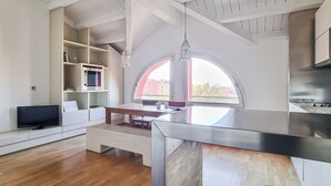 Una cocina moderna con una isla grande, horno empotrado y una zona de comedor con banco.