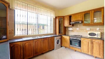 Departamento Deluxe, 2 habitaciones, vista al jardín | Cocina privada | Refrigerador, microondas, horno y parrilla de estufa