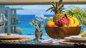 Ein Tisch mit Obstschale, Weinglas und Blick auf das Meer.