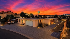A residential property with a paved driveway, a garage, and a golf cart. - Tiny Beach Boardwalk Bungalow D | Rooftop Retreat (Fort Walton Beach)