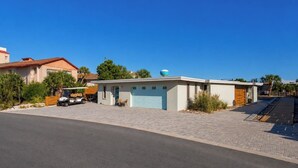 A modern two-story house with a garage, a golf cart, and a clear blue sky. - Tiny Beach Boardwalk Bungalow D | Rooftop Retreat (Fort Walton Beach)