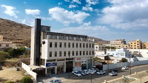 A hotel with a modern design, featuring a flat roof and a large glass facade. - qimampark albaha7 (Al Baha)