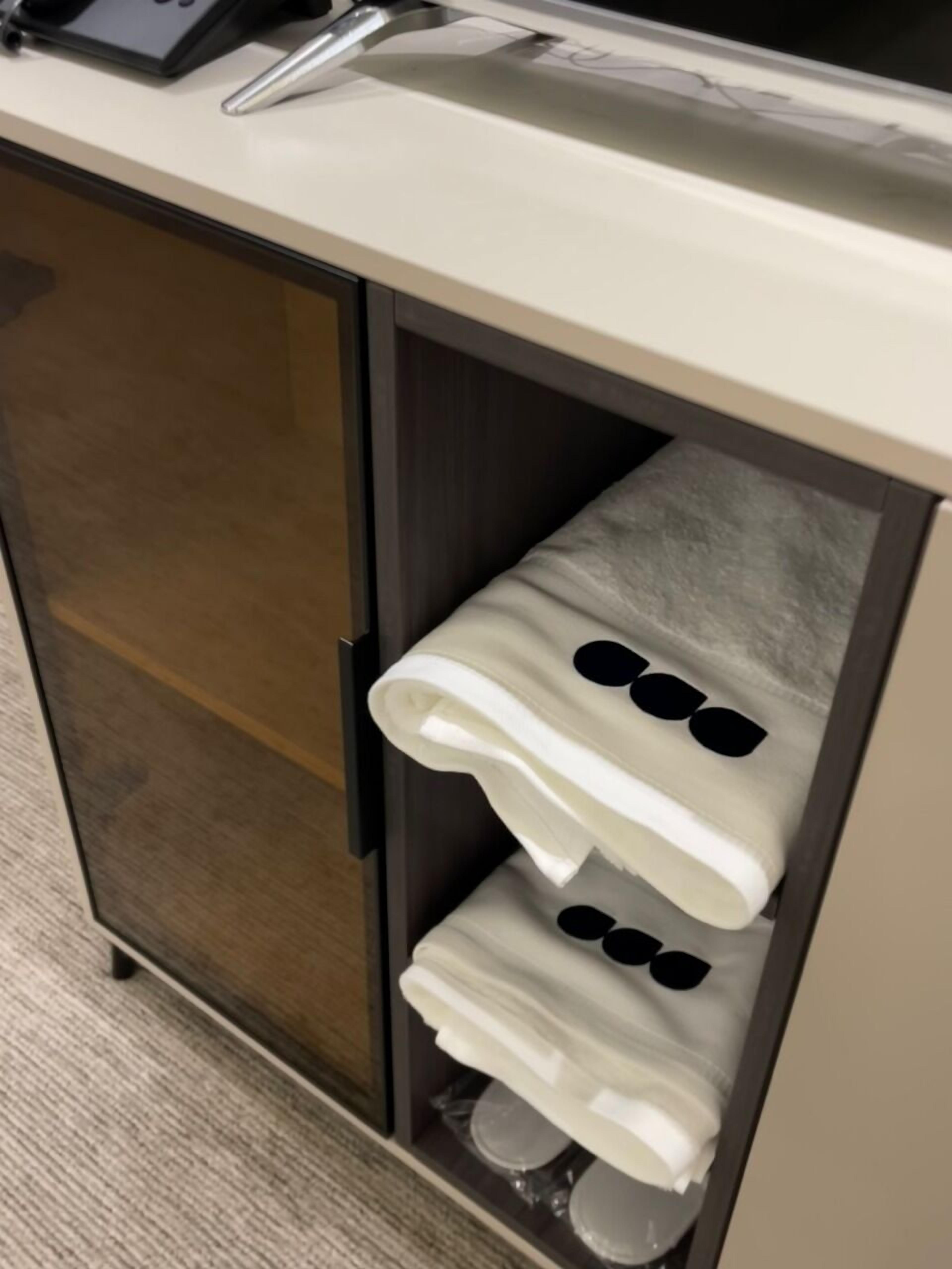 A hotel minibar with a built-in towel warmer and a small sink.