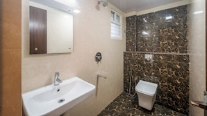 Un baño con lavamanos, inodoro y ducha.