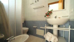 A bathroom with a toilet, sink, and shower area. - Vacation Home Aphrodite Torre Mozza (Torre Mozza)