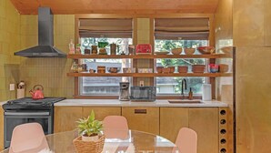 Eine moderne Küche mit Herd, Spüle und einem Essbereich mit Tisch und Stühlen.