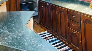A kitchen with wooden cabinets, a stove, and a tiled backsplash.