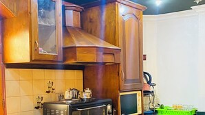 A kitchen with wooden cabinets, a microwave, a stove, and a coffee maker.