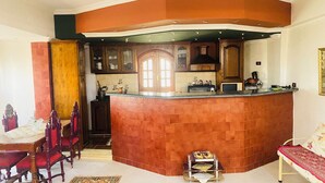 A kitchen with a curved island, wooden cabinets, and a dining area with a table and chairs.