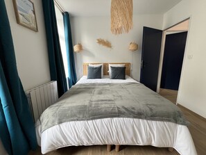 A neatly made bed with a grey and white duvet, a wooden headboard, and two bedside lamps. - L'Oasis Urbaine - 2-4p, downtown, Place Dalton (Boulogne-sur-Mer)