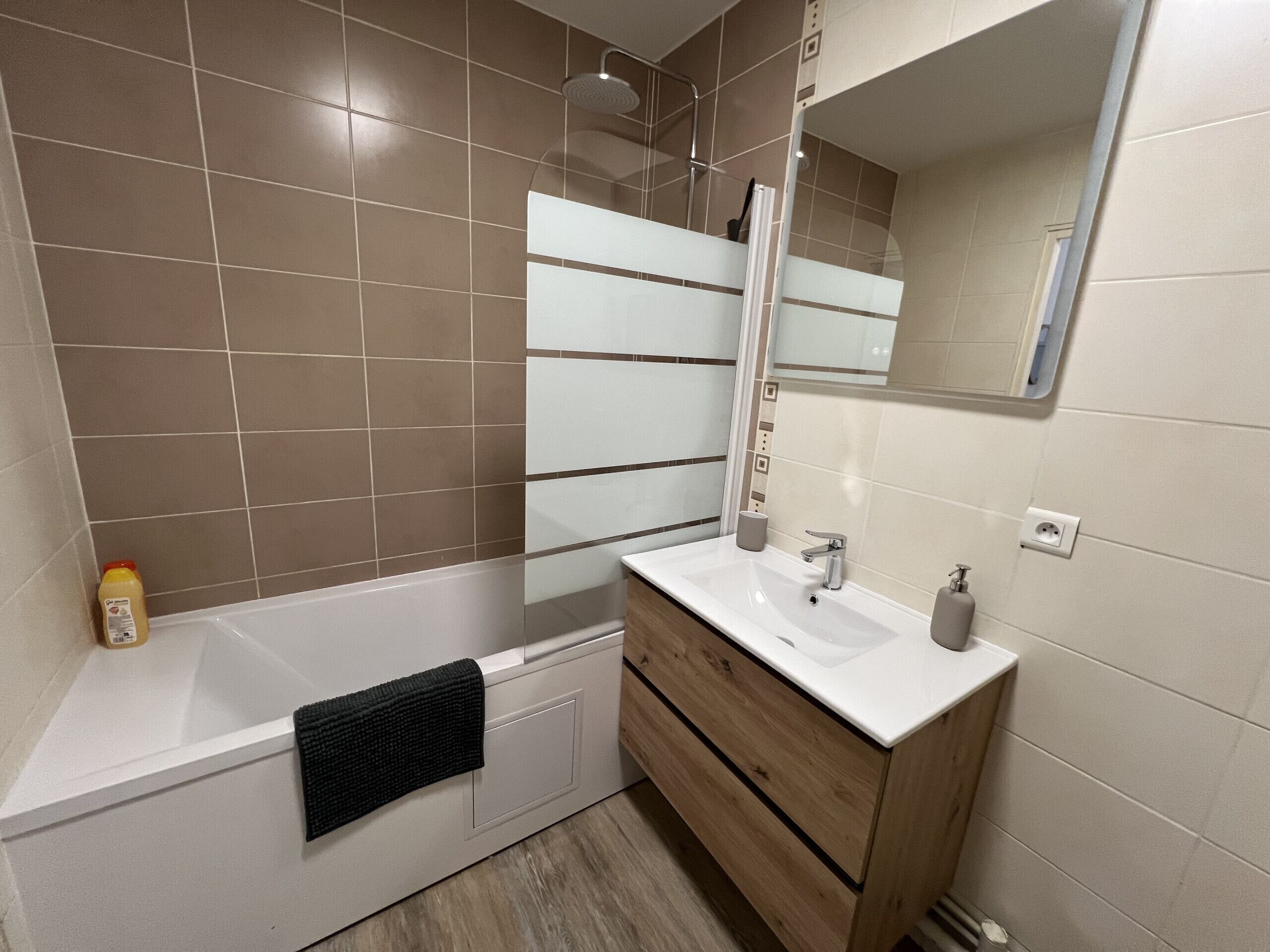 A modern bathroom with a bathtub, a sink, and a mirror.